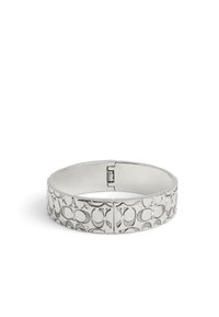 Silverfärgad banglesmycke med en texturerad mönster med cirkulära designer och små accentstenar. Slät yta med gångjärnsstängning.