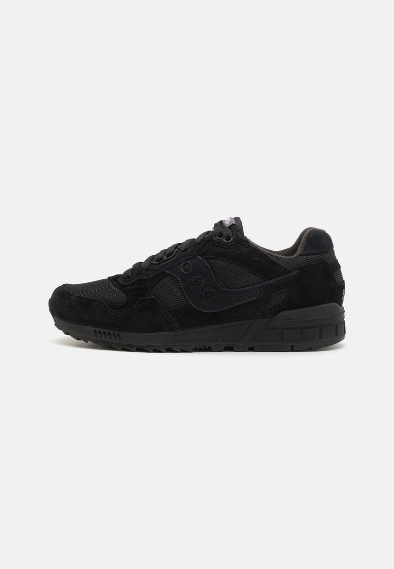 Scarpe sportive nere in suede e rete, con una superficie testurizzata, punta arrotondata e una suola in gomma con motivo e dettagli.