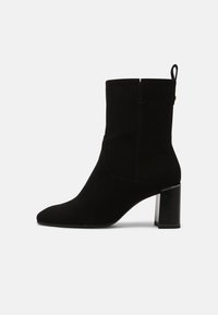 Czarny zamszowy botek za kostkę z ostrym noskiem, 5 cm grubym obcasem i tylną pętelką ułatwiającą zakładanie. Gładka tekstura i minimalistyczny design.