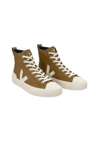 Zapatillas altas de lona marrón con suelas de goma blanca y cordones. Presentan un logo en forma de V blanca en el lado exterior y tejido texturizado.