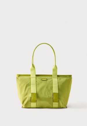 Bolso tote Lancel de color verde claro con asas dobles para el hombro y una pequeña placa del logo en la parte delantera, sobre un fondo claro y liso.