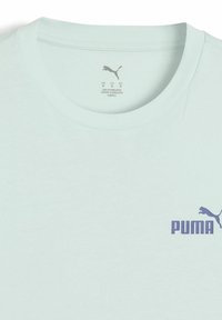 Vaaleanvihreä crew neck -t-paita, joka on valmistettu puuvillasta ja jossa on etupuolella violetti "PUMA" -logo sekä sileä pinta.