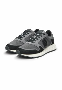 Zapatillas deportivas grises y negras con materiales de malla y ante, diseño de cordones, cuello acolchado y suela de goma blanca contrastante.