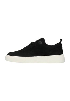 Baskets basses noires en suède, lacets noirs et semelle épaisse en caoutchouc blanc, vues de profil sur fond blanc.