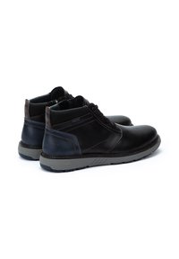 Botas de tobillo de cuero negro con acentos azules, que presentan un acabado texturizado, diseño con cordones y suelas de goma gris duraderas.