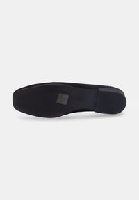 Chaussure noire plate avec une tige lisse et une semelle en caoutchouc texturée. Présente un bout arrondi et un design minimaliste sans accents ni motifs visibles.
