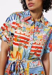 Mehrfarbiges Button-Up-Hemd aus leichtem Stoff, mit Blumen- und geometrischen Mustern, kurzen Ärmeln und einem gebundenen Taillendetail.