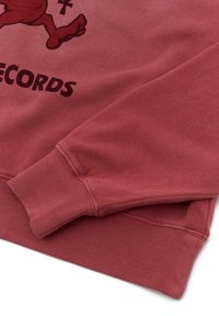 Red sweatshirt featuring ribbed cuffs and hem, with a smooth texture and a graphic print on the front reading "RECORDS."