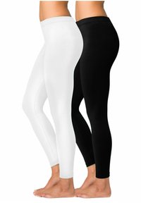 Twee paar leggings naast elkaar weergegeven: één wit, één zwart. Beide zijn gemaakt van rekbare stof, hebben een aansluitend ontwerp en zijn enkel-lang.