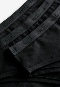 Zwarte stoffen ondergoed met een zachte, elastische tailleband met herhaalde "self." branding. De textuur ziet er glad en rekbaar uit.