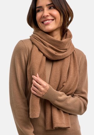 Brauner Schal aus weichem Stoff, der um den Hals drapiert ist. Der Look ist lässig, mit einer glatten Textur und subtilen Glanz. Wird über einem passenden Pullover getragen.