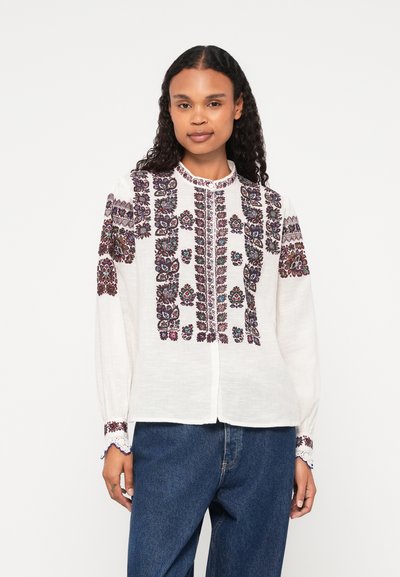 Blusa bianca con elaborati ricami floreali multicolori lungo la parte anteriore e le maniche, con collo alto e patta per i bottoni.