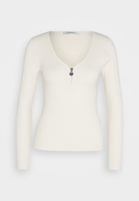Maglia bianca a maniche lunghe con costine, caratterizzata da un profondo scollo a V e chiusura a zip al collo. Design aderente e leggero con una texture liscia.