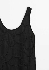 Haut noir sans manches avec larges bretelles et motif abstrait de couture patchwork sur le tissu.