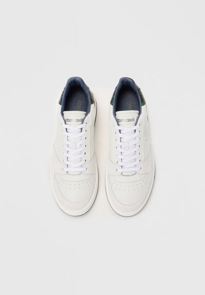 Vita lädersneakers med rund tå, kontrasterande mörkblå insida och gröna mönstrade accenter på baksidan. Har vita snören och perforeringar.