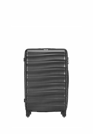 Czarna walizka z twardą obudową z poziomymi falistymi wzorami, czterema obrotowymi kółkami i górnym uchwytem.