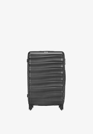 Czarna walizka z twardą obudową z poziomymi falistymi wzorami, czterema obrotowymi kółkami i górnym uchwytem.