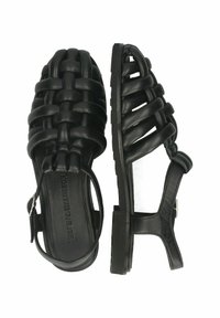 Schwarze Ledersandalen mit einem geflochtenen Oberdesign, offener Zehenpartie, verstellbarem Knöchelriemen und einer flachen Gummisohle.