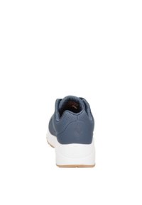 Scarpa sportiva blu navy con retro testurizzato, intersuola bianca e suola esterna marrone chiaro. Presenta fori di ventilazione sul tallone per la traspirabilità.