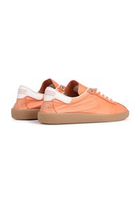Zapatillas de cuero naranja con acentos blancos, suela de goma y detalles de tachuelas en el talón. Presentan cierre con cordones y superficie texturizada.