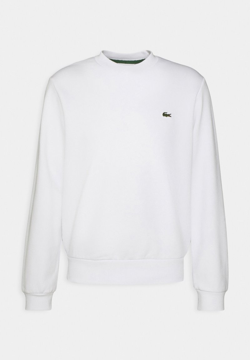 Sweat-shirt blanc à manches longues et col rond avec poignets et ourlet côtelés, présentant un petit logo crocodile vert sur la poitrine gauche.
