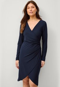 Marineblaue Wickelkleid mit langen Ärmeln, V-Ausschnitt und strukturiertem Stoff. Verfügt über eine taillierte Taille und einen asymmetrischen Saum für zusätzlichen Detailreichtum.