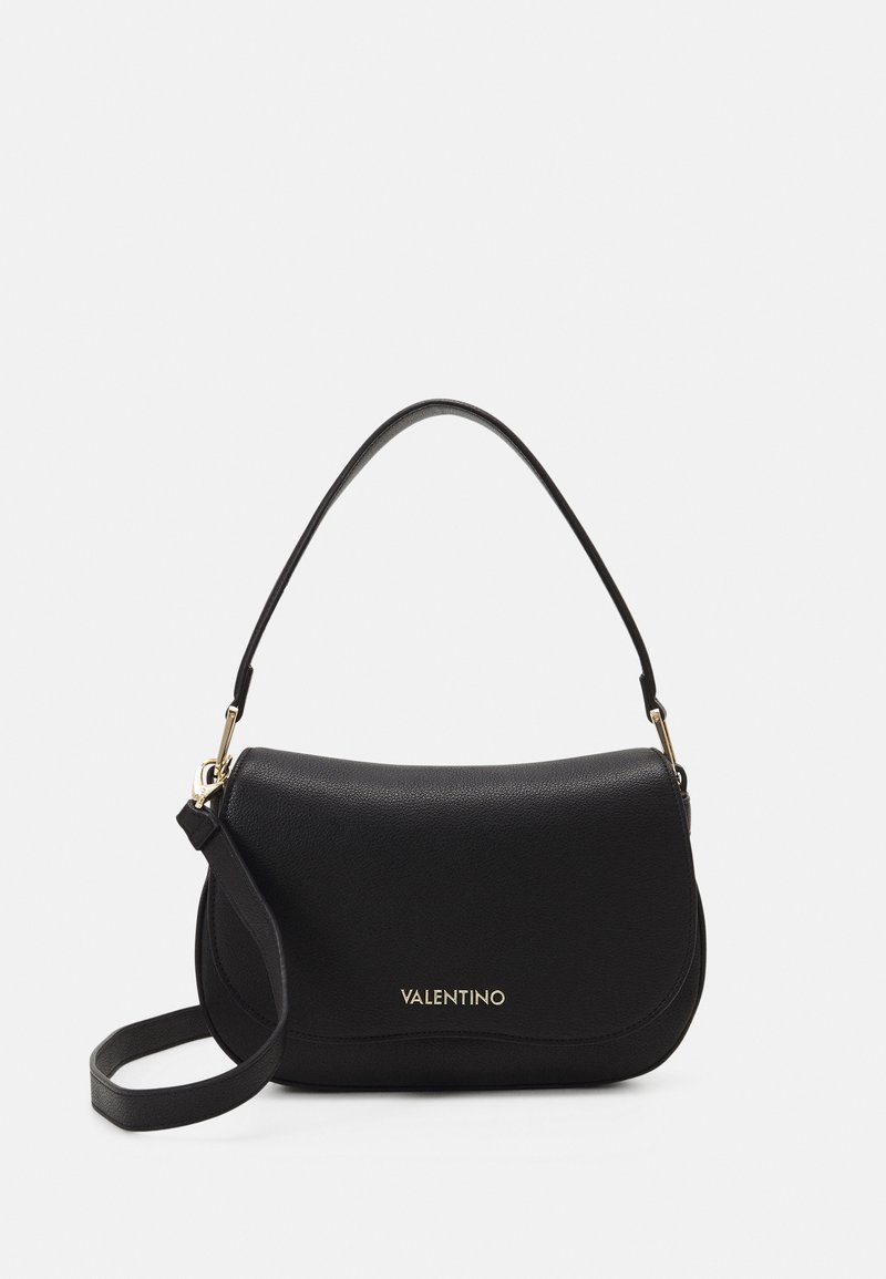 Sac à épaule en cuir noir avec une forme courbée, doté d'un dessus plat, d'une courte poignée et de garnitures en or. Le nom de la marque est estampé à l'avant.