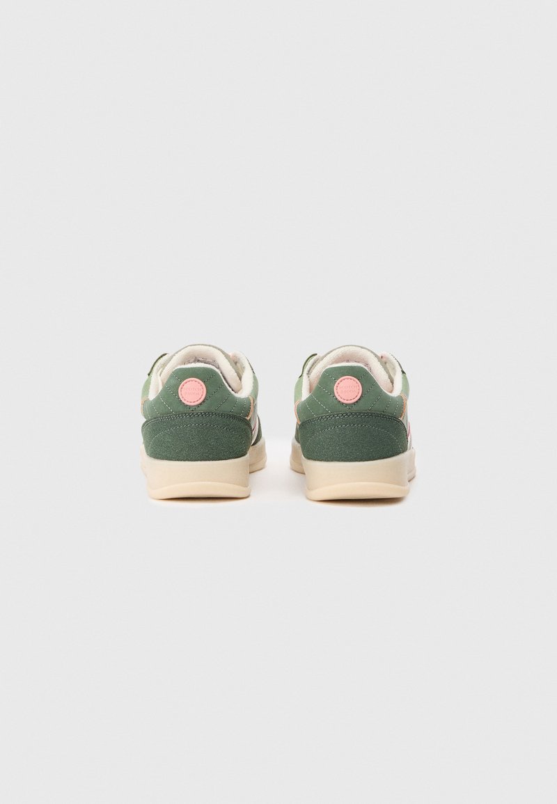 Groene sneakers met zachte stof, een beige zool en roze accenten. Decoratieve stiksels en een rond logo op de hiel zijn opvallende details.