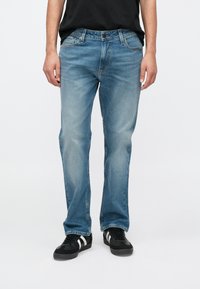 Ανοιχτό μπλε τζιν παντελόνι με ίσια γραμμή και διακριτικό ξεθώριασμα. Διαθέτει παραδοσιακό σχέδιο με πέντε τσέπες και κλείσιμο με μπροστινό κουμπί.