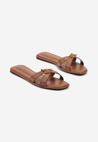 Sandales en cuir marron à bandes croisées, avec une boucle dorée et une semelle plate. Semelle intérieure texturée pour le confort.