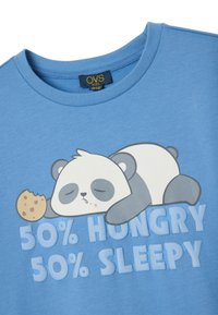 Camiseta de algodón azul claro con un panda de dibujos animados con los ojos cerrados, una galleta y el texto "50% HAMBRIENTO 50% DURMIENDO."