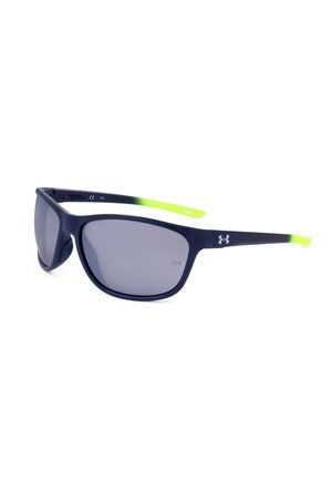 Occhiali da sole neri opachi con lenti scure, punte delle aste traslucide verde neon e logo Under Armour bianco sull'asta.