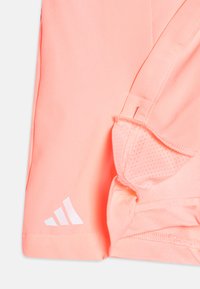 Pantalones cortos deportivos cortos de color rosa con un diseño transpirable, que cuentan con acentos de malla texturizada y un logo blanco en la esquina inferior izquierda.