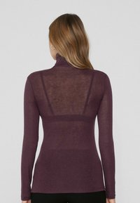 Dlouhý rukáv fialového roláku s průhlednou zadní částí a přiléhavým střihem, vyrobený z měkkého, lehkého materiálu. Hladká textura po celém povrchu.