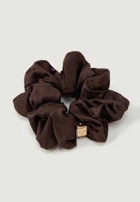 Scrunchie de cetim castanho com acabamento texturizado e um encanto quadrado dourado. Design suave e franzido, ideal para pentear ou decorar o cabelo.