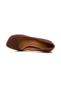 Zapato plano de ante marrón con puntera redondeada y diseño bajo, que presenta un forro interior suave y una construcción sin costuras.