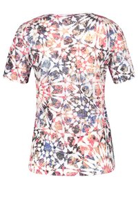 Camiseta de manga corta con un colorido patrón geométrico en rosa, azul y negro sobre un fondo blanco. Fabricada con tela suave.