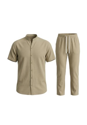 Beige kortemouwen blouse met knopen en mandarijnkraag, gecombineerd met beige broek met trekkoord op een witte achtergrond.