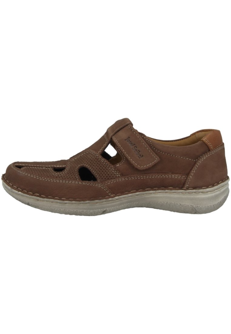 Brown leather shoe with cut-out design, Velcro strap, and contrasting light-colored sole. Features stitched detailing and soft interior lining.