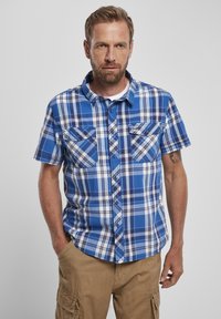 Kék és fehér kockás, rövidujjú ing, gombos gall�érral, két mellet zsebből és ívelt alsó szegéllyel.