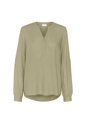 Blusa a maniche lunghe in verde oliva chiaro, con scollatura a V e patta con bottoni. Realizzata in un tessuto liscio con orlo arrotondato e polsini con bottoni.
