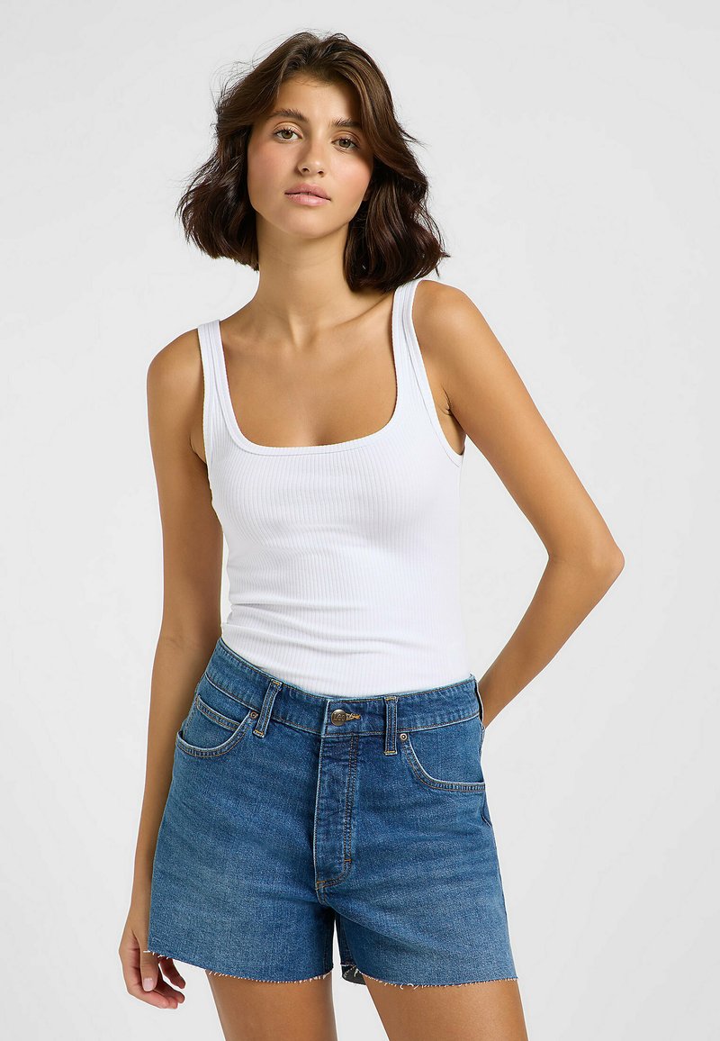 Weißes, geripptes Tanktop mit quadratischem Ausschnitt, kombiniert mit hoch taillierten blauen Jeansshorts mit fransigem Saum und klassischem Fünf-Taschen-Design.