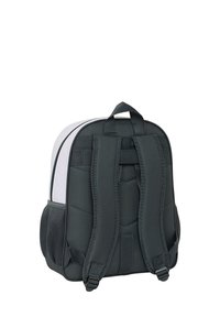 Zaino bianco e nero visto da dietro che mostra spallacci imbottiti, una maniglia superiore e tasche laterali in rete su sfondo bianco.