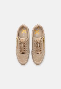 Baskets en daim beige avec accents dorés, comportant des lacets, une fermeture éclair latérale et un bout arrondi. L'intérieur présente un logo imprimé.