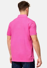 Kortermet polo skjorte i livlig rosa bomull, med klassisk krage og sidelommer, med en glatt tekstur og en uformell passform.