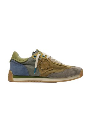 Zapatilla baja en ante verde, azul y marrón con tela, cordones blancos y suela texturizada.