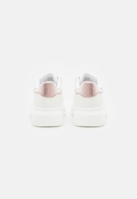 Weiße Sneaker mit einer strukturierten roségoldenen Fersenlasche und weißen Sohlen. Glatte Oberfläche mit einem gepolsterten Kragen und minimalistischem Design.