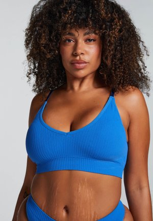Blauw geribbeld crop top met een v-hals en verstelbare bandjes. Heeft een brede, gestructureerde band aan de onderkant. Geschikt voor casual wear.