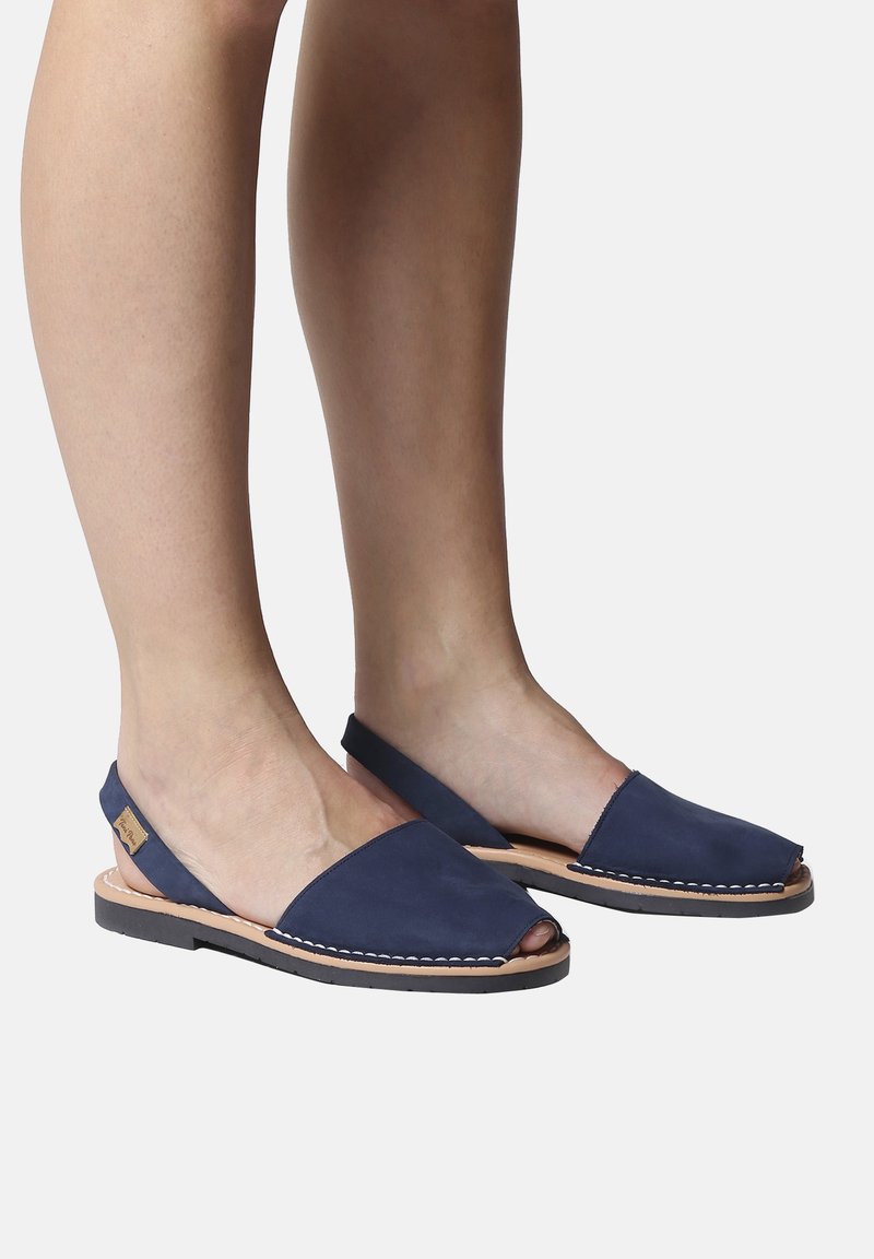 Tummansiniset slingback-sandaalit, joissa on avokärkinen muotoilu, nahkavarsi, ommellut yksityiskohdat ja kumipohja.