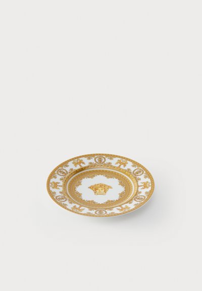 Bílý porcelánový talíř s komplikovanými zlatými barokními vzory a středovým motivem Medúzy.